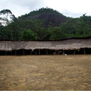 Landsbyen består av ett stort, sirkelformet felleshus. Den åpne plassen i midten brukes både til fest og lek. Husets eneste vegg er mot regnskogen. (Foto: Rainforest Foundation Norway / ISA Brazil)